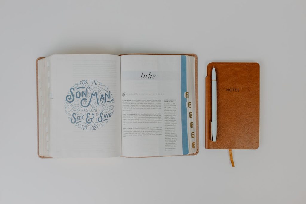 pexels-photo-8383412 Flat lay of an open Bible next to a notebook and pen, ideal for faith and study themes.